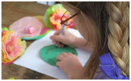 A kid making a craft for her father with a personal touch