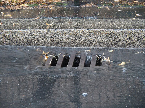 Urban runoff entering a storm drain Urban runoff entering a storm drain